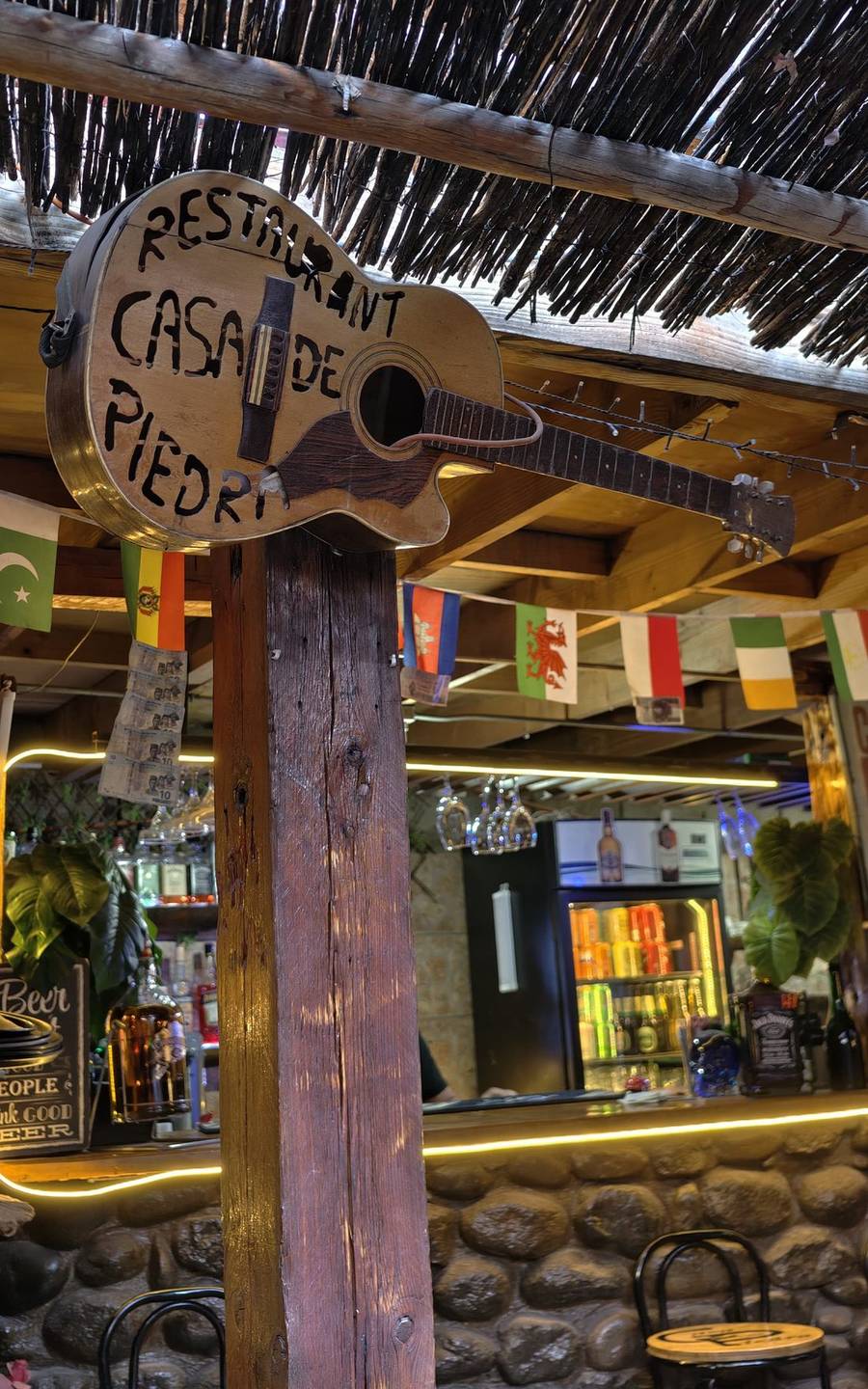 Guitarra de madera con el letrero del restaurant, música en vivo