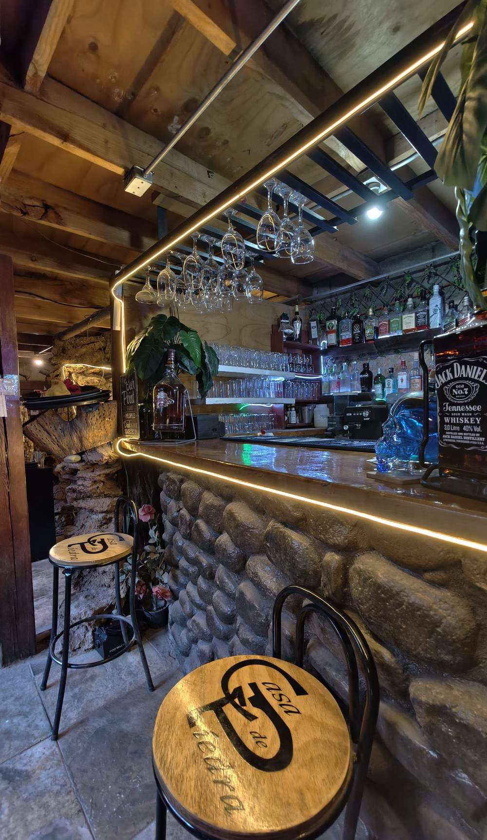 Barra interior con luces cálidas y copas colgantes