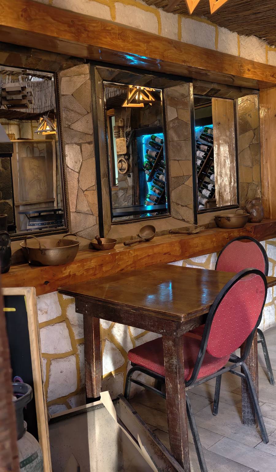 Barra con espejos de piedra y ollas de cobre decorativas